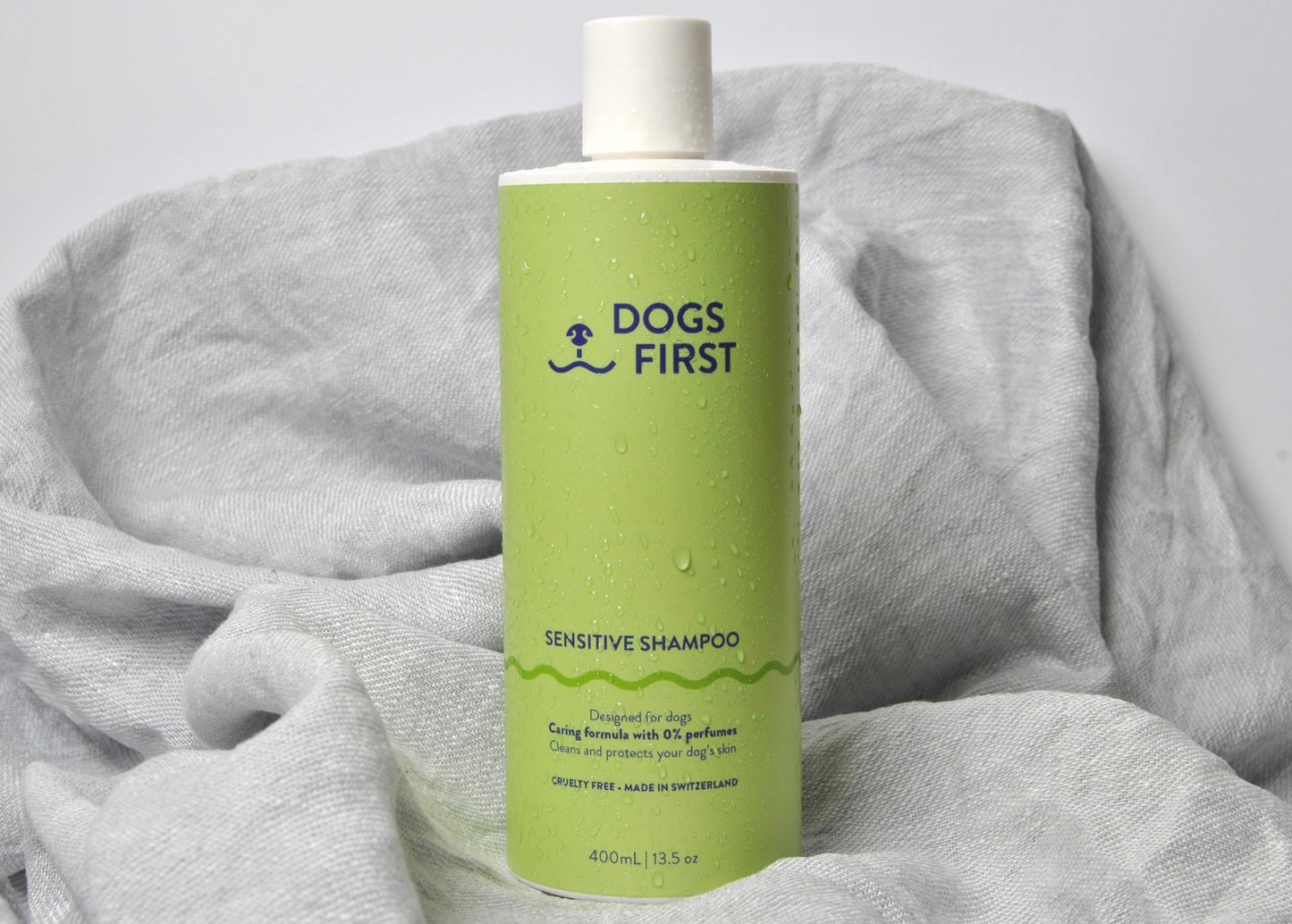 Dog shampoo bottle on grey towel - gentle sensitive skin formula made in Switzerland