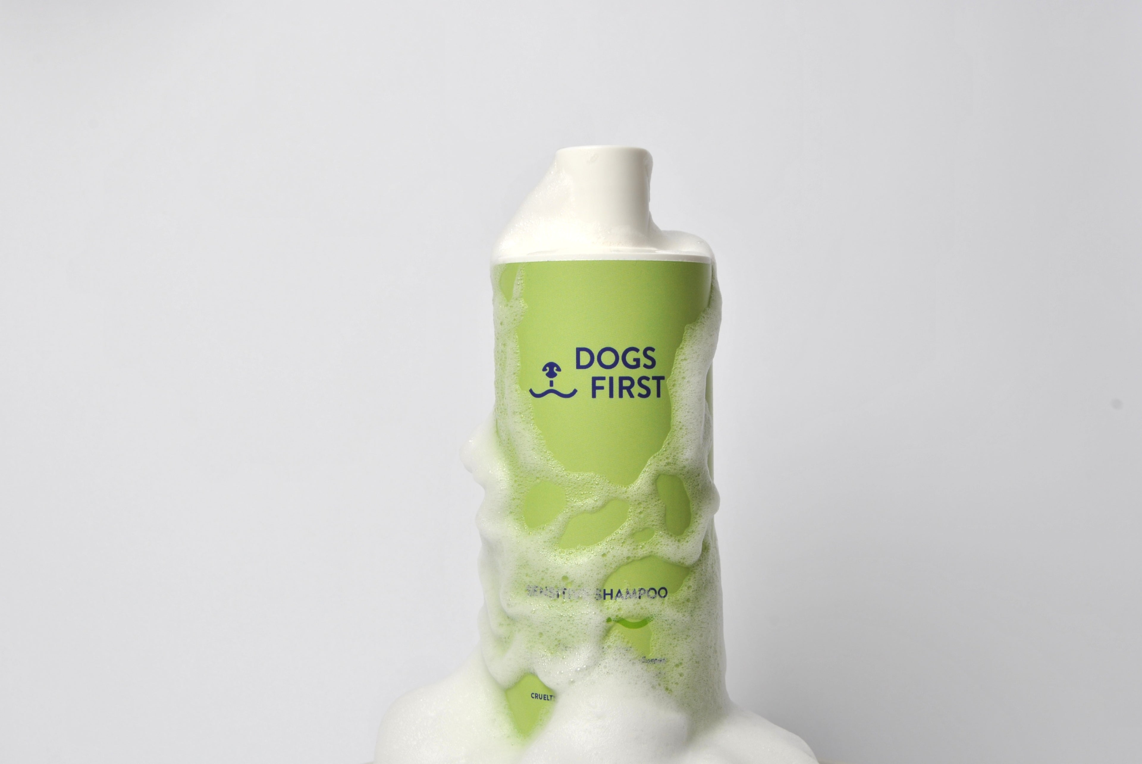 DOGS FIRST Made in Switzerland. Bottle of dog shampoo covered in foam